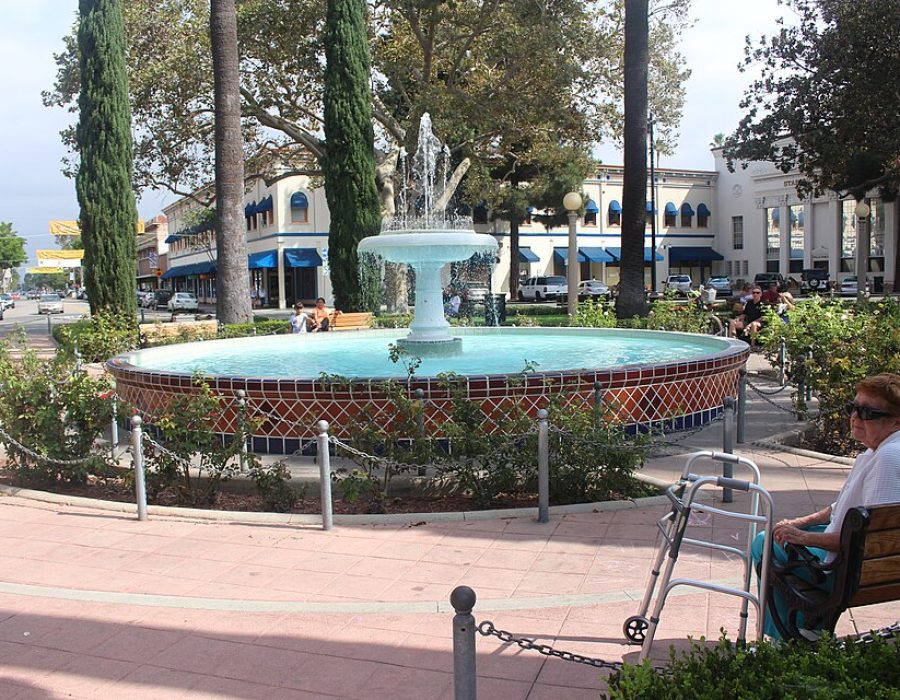 Fountain surrounded by greenery and benches.